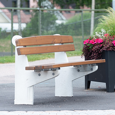 Grote parkbank met een wit betonnen frame en houten zitting en rugleuning.